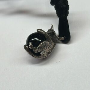Artsy cat pendant holding a black orb marble